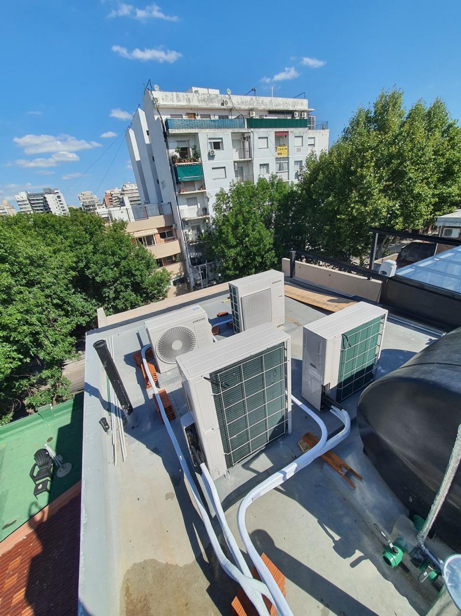 Terraza de edificio con unidades de aire acondicionado y tanque de agua — proyecto INSTALACIONES , por CLIMA STAR SRL , en Pichincha 167